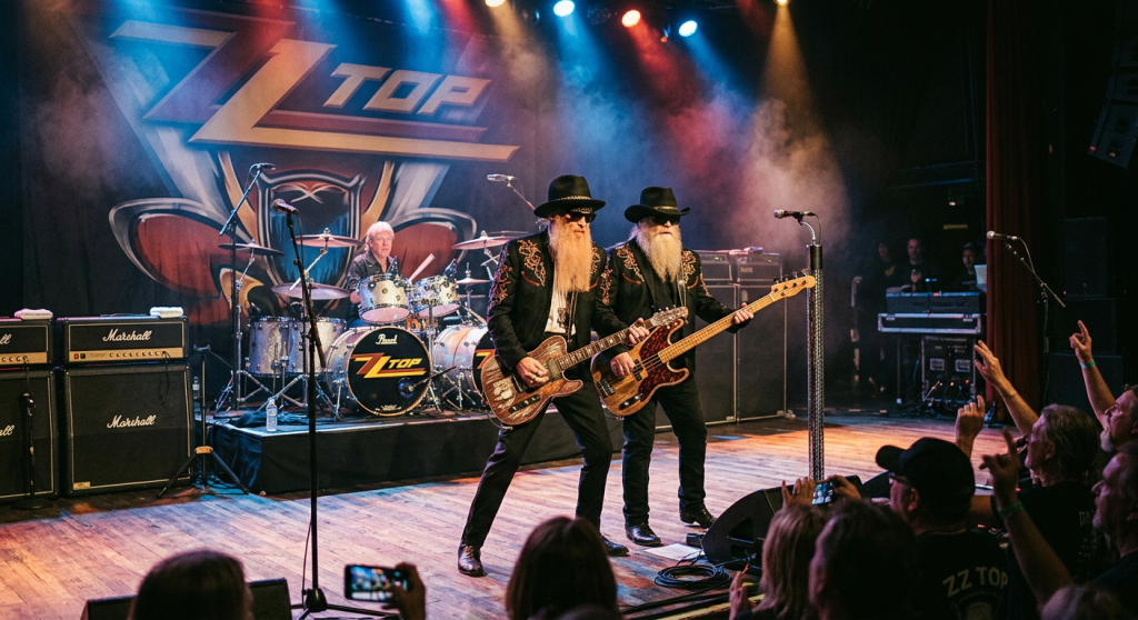 ZZ Top band performing live with two guitarists front and drummer behind
